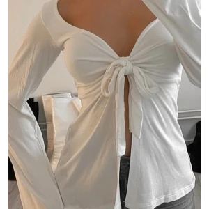Vit långärmad omlottopp med knyt - Hej ! Jag säljer nu denna fina tröja från Designbysi i storlek XS/S. Trendig vit långärmad topp med djup v-ringning och knyt framtill. Modellen har lätt utsvängda ärmar och sitter snyggt figurnära över bysten. Toppen är använd ett fåtal gånger!  Hör av er vid funderingar, skriv privat för fler bilder🩷 