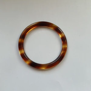 Brun smal bangle  - Säljer min bangle pga ingen användning. Det är min farmors gamla, och jag tror den är från typ 80 eller 90-talet? Den har en diameter på ca 6,4 cm och en omkrets på ca 21 cm (20,96 cm för att vara exakt)!