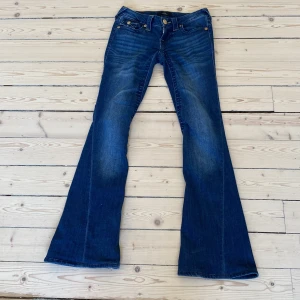 True Religion Joey Low Rise Flare Jeans - Säljer ett par blå True Religion Joey jeans med låg midja och utsvängda ben. Köpte de på best of brands och sydda upp de där och passar mig i längden som är 162. Säljer för att de inte passar längre. Nypris 1700kr.💗