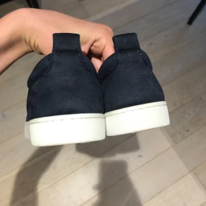 Mörkblåa sneakers med nitar från Christian Louboutin - Säljer ett par as feta mörkblåa sneakers från Christian Louboutin med mörkblåa nitar på tån och vit sula. Dem är i den mest eftertraktade färgen och är super feta inför sommaren och våren! Dem är använda 2-3 gånger men visar inga tecken på användning!✅ Dust, box och kort ingår! Pris är absolut diskuterbart!