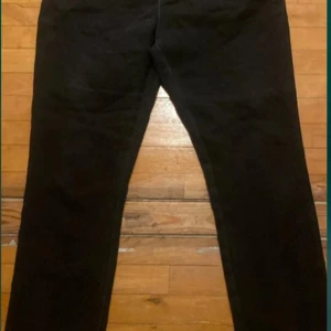 Svarta byxor från Micha, modell Emma - Svarta byxor från Micha i modellen Emma. Klassisk rak passform med normal midja och två bakfickor. Byxorna har en diskret läderdetalj med stjärna på baksidan. Perfekta för en stilren look.