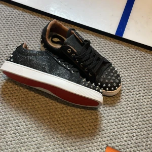 Svarta sneakers med nitar och röd sula - Skor 