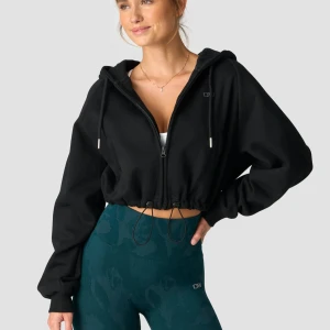 Svart croppad hoodiejacka från ICANIWILL - Svart croppad hoodiejacka med dragkedja och justerbar dragsko i midjan. Felfri, den bara har lite päls som det går bra att ta bort. Nypris: 699 kr