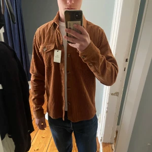 Brun manchester overshirt från Ciszere - Säljer en brun manchester overshirt från Ciszere med klassisk krage och knappar framtill. Skjortan har två bröstfickor framtill och är i nyskick! I butik 1099kr nu endast 449👊