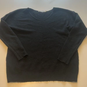 Svart stickad tröja från Lager157 - Mysig svart stickad tröja från 157 med v-ringning och långa ärmar. Perfekt för lager-på-lager och passar till många olika outfits. Klassisk modell med ribbade muddar vid ärmslut och nederkant. Lite knopprig.