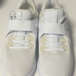 Vita Nike Air Max sneakers - Säljer ett par fräscha vita Nike Air Max sneakers med bred kardborre över vristen och klassisk snörning. Skorna har en modern design med diskreta detaljer och mönstrad sula för bra grepp. Perfekta för dig som gillar stilrena och sportiga skor. Använt en gång💕
