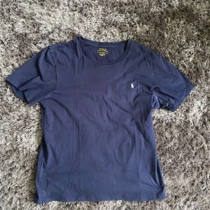 Mörkblå t-shirt från Polo Ralph Lauren - Säljer en klassisk mörkblå t-shirt från Polo Ralph Lauren med liten broderad logga.. Perfekt för en stilren och enkel look. Storlek M och i mycket bra skick. Hör av er vid intresse!!