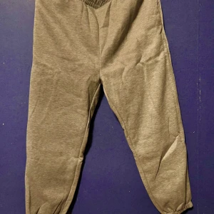 Grå mjukisbyxor med resår - Gråa mjukisbyxor med elastisk midja och muddar vid bensluten. Byxorna har en enkel och avslappnad design, perfekta för chill dagar eller när du vill vara bekväm. Tillverkade i mjukt material som känns skönt mot huden. Aldrig använda 