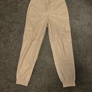 Beige cargopants med resår - Snygga beige cargopants med resår vid benslut och stora fickor på sidorna. Perfekta för en avslappnad och trendig stil. Byxorna har normal passform och praktiska detaljer som gör dem både stilrena och funktionella 🤎👖