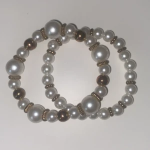 Fina pärlarmband med gulddetaljer! 1st för 25kr 2st för 40kr - 1st för 25kr 2st för 40kr. Säljer två elastiska armband med vita pärlor och guldfärgade detaljer. Det ena armbandet har även större guldfärgade kulor blandat med pärlorna, medan det andra har enbart vita pärlor och små gulddetaljer mellan varje pärla. Perfekt accessoar för att lyfta din outfit.