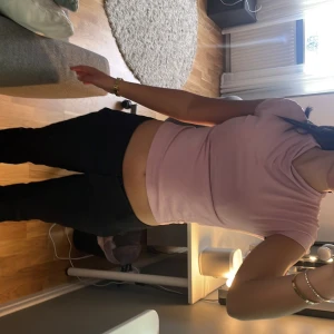 Ljusrosa croppad t-shirt - Säljer en ljusrosa croppad t-shirt med korta ärmar och rund halsringning. Perfekt för en avslappnad och trendig stil.