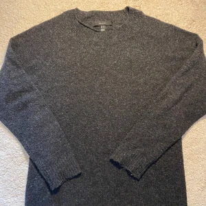 Vero Moda Tröja - Mysig mörkgrå stickad tröja från Vero Moda. Tröjan har rund halsringning och långa ärmar med ribbade muddar. Perfekt för kyligare dagar och enkel att matcha med olika outfits.