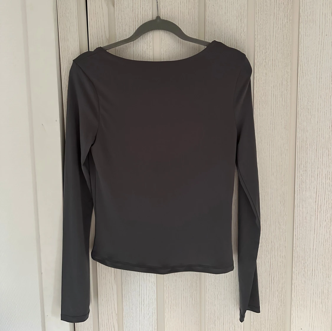 Mörkgrå långärmad topp med djup urringning i ryggen