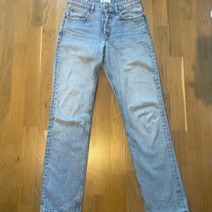 Ljusblå raka jeans från Zara - Säljer ett par ljusblå jeans från Zara med klassisk femficksdesign och raka ben. Jeansen har normal passform och stängs med knapp och dragkedja. Perfekta till vardags för en avslappnad stil.