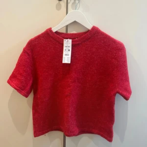 Röd stickad kortärmad tröja - Säljer en röd stickad kortärmad tröja med rund halsringning. Tröjan har en mjuk och mysig känsla och är perfekt för dig som vill ha något enkelt men ändå snyggt. Passar till många olika stilar! Säljer då den är för liten på mig som är storlek S-M