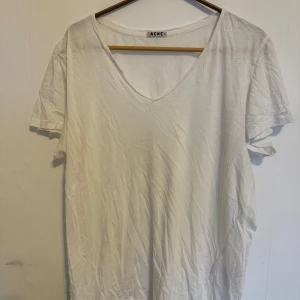Vit v-ringad t-shirt från Acne Studios - T-shirten är flitigt använd och sitter rätt löst på kroppen