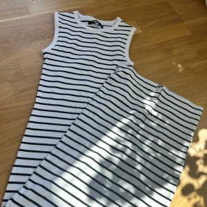 Vit och svart randig ärmlös klänning - Säljer en vit ärmlös klänning med ränder, den är ribbad och är perfekt för varma dagar och enkel att styla! Från bikbok, strl S och säljer för 150 kr, aldrig använd