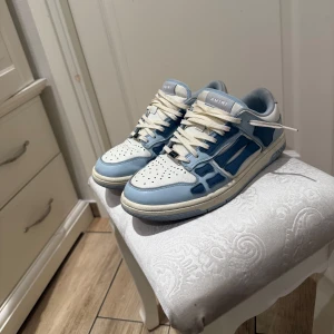 Amiri Skeleton Sneakers - Säljer ett par Amiri sneakers i blått och vitt. Skorna är köpte utom lands där jag även tyvärr lämnade boxen. Skorna är 1000% äkta. Pris går att diskutera vid smidigt köp.