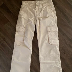 Beiga cargopants med raka ben - Säljer ett par beige cargopants med raka ben och stora fickor på sidorna. Perfekta för en avslappnad och trendig stil. De är i mid/low waist. Använda en gång men har lyckats få en minimal fläck på baksidan som säkert går bort i tvätten. Swipea för att se🤍💞🌸