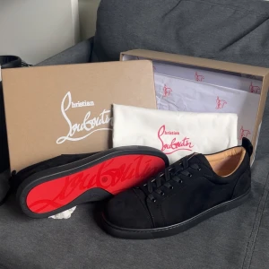 Louboutins skor svart utan spikar - Svarta sneakers från Christian Louboutin i mocka  med klassisk röd sula. Storlek 48 för de långa stora grabbarna (som mig) Helt nya aldrig använt = perfekt skick. Fodrade med beige läder för extra komfort. Alla brudar kommer att springa efter dig med de här skorna! OBS! Glömde säga att de är äkta bara för 3499!😱🤯