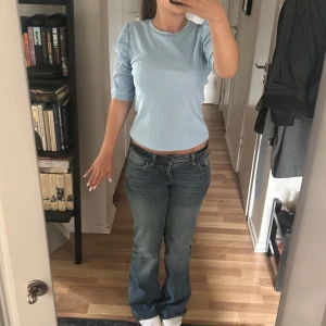 Ljusblå ribbad topp - Säljer en ljusblå ribbad topp med korta ärmar och rund halsringning. Toppen har en tight passform och är tillverkad i ett mjukt, stretchigt material som sitter snyggt på kroppen. Perfekt för en enkel och fräsch look.💌Köparen står för frakten!