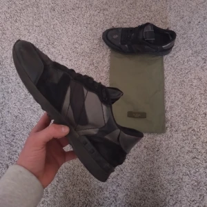 Valentino rockrunners - Säljer ett par svartsilvriga valentino rockrunners. Skorna är i bra skick förutom en slitskada vid hälen på båda skorna på insidan (se sista bilden). Skorna är självklart äkta. Valentino dustbag medföljer. Hör av er vid frågor.