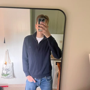 Mörkblå stickad tröja med dragkedja från Polo Ralph Lauren - Säljer en mörkblå stickad tröja från Polo Ralph Lauren med dragkedja framtill. Perfekt för kyligare dagar eller sena sommarkvällar 🌅. Tröjan har använts lite då och då men skicket är på topp! Skriv privat vid minsta lilla fundering, svarar så snabbt jag kan! 🙌. Fraktar alltid inom 24h!📦                            Nypris: Ca 2300kr.                            Mitt pris: 599kr