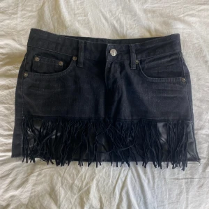 Svart jeanskjol med fransar - Cool svart jeanskjol med fransdetaljer längst ner. 