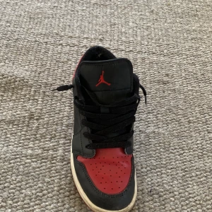 Nike Air Jordan 1 Low svart/röd/vit - Säljer mina air Jordan lows, säljer för att jag har växt ut dem och inte behöver dem längre, köpta på footlocker i Barcelona. Strl 38