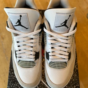 Nike Air Jordan 4 Retro - Military Black - Nike Air Jordan 4 retro Military Black helt oanvända med box. Köpta via Nike appen. Skorna har meshpaneler, snörning och detaljer i svart plast. Ovandel i skinn och mocka, samt en robust sula med synlig Air-enhet. Perfekta för dig som vill sticka ut med en ikonisk sneaker. Perfekt till sommaren men passar även med jeans.