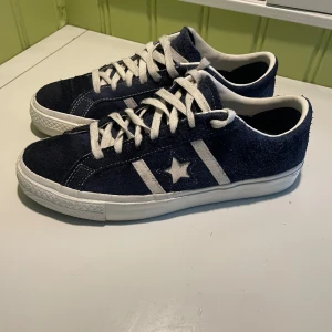 Mörkblå Converse sneakers i mocka - Säljer nu ett par mörkblå Converse One Star i storlek 42. Säljes på grund av att dom inte passar mig som har storlek 43. Köptes för ca 2 månader sen och inte använts jätte mycket sedan dess så de är i fint skick. Nypris ca 1300 kr. Hör av dig om du har några frågor!