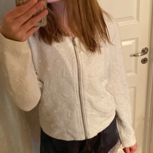 Vit quiltad jacka från KappAhl - Säljer en vit quiltad jacka från KappAhl i storlek M. Jackan har dragkedja framtill, rund halsringning och ett snyggt geometriskt mönster i tyget. Perfekt för lager-på-lager och ger en clean look.