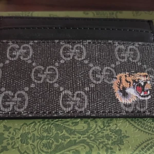 Korthållare med tigerbroderi - Säljer en snygg korthållare i svart och en broderad tiger på framsidan. Perfekt för dig som vill ha en stilren accessoar med lite edge.