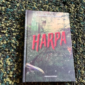 Harpa - En spännande bok med mystiska och skrämmande inslag, perfekt för dig som gillar äventyr och mysterier. Omslaget visar en skog, en ensam sko och ett djur, vilket ger en känsla av fara och nyfikenhet. Passar unga vuxna som vill ha något riktigt nervkittlande.