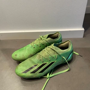 Gröna Adidas fotbollsskor med svarta detaljer - Säljer ett par gröna fotbollsskor från Adidas med svarta detaljer och snörning. Skorna har en modern design med dobbar för bra grepp på planen. Perfekta för fotbollsspelare som vill sticka ut. Skorna är i bra skick och är en av dem dyrare modellerna,nypris är runt 2300kr| bara höra av sig vid frågor! Priset ej hugget i sten. Storlek 40 o 2/3 men passar 40-41
