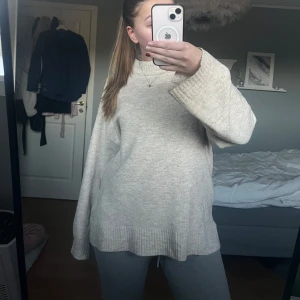 Beige stickad oversized tröja - Mysig beige stickad tröja med breda ärmar och ribbade muddar. Tröjan har en avslappnad, oversized passform och är perfekt för kyligare dagar. Enkel och stilren design som passar till det mesta. 