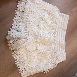 Spetsshorts vita  - Superfina vita shorts med lågmidja. I spets med blommor. Passar xs /s