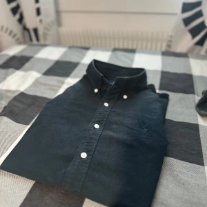 Polo ralph lauren skjorta  - Raffe skjorta i prima skick förutom en knapp som saknas men alla extra finns, men tycker dock den ser fetare ut utan men som sagt är det bara att fixa annars felfri och riktigt snygg . Dessutom har skjortan en svart häst vilket inte är  ofta de har