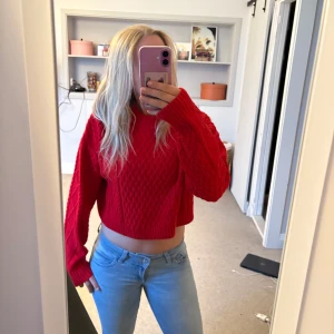 Röd croppad stickad tröja - Säljer en röd croppad stickad tröja med lång ärm och snyggt mönster. Passar till både jeans och kjol. Endast använd en gång och priset går att diskutera💘