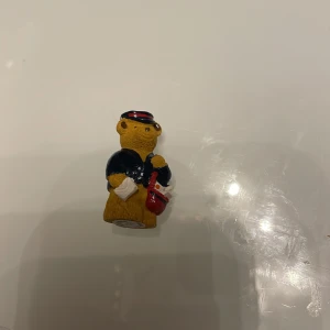 Sammlarfigur  - En sammlarfigur miniatyr av en nalle det har blivit en liten flisa på kepsen se bild 