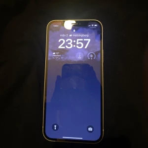 iPhone 12 - 📱 iPhone 12 – Stilren och kraftfull smartphone  Denna iPhone 12 har en snygg och modern design med raka aluminiumkanter och en glasbaksida. Telefonen på bilden är i utmärkt skick och har ett skyddande skal (möjligen transparent eller med gul nyans), vilket tyder på att den varit väl omhändertagen. 3000 kr eller bud.