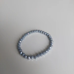 Blått glittrigt pärlarmband - Snyggt armband med små, facetterade pärlor i ljusblått som ger ett glittrigt intryck. Perfekt accessoar för att lyfta din outfit med lite extra bling. Elastiskt band gör det enkelt att ta på och av.