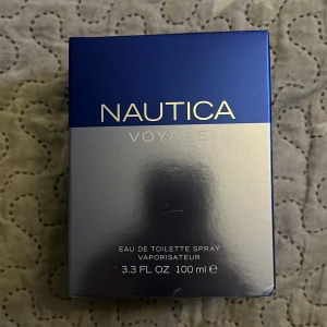 Nautica Voyage Eau de Toilette 100 ml - Säljer min Nautica Voyage EdT 100 ml – endast använd ca 15 sprut, så flaskan är nästan helt full. Frisk, marin doft med inslag av äpple, lotus och trä. Perfekt för vardagsbruk. Köpt ny, äkta vara. Inga skador på flaskan