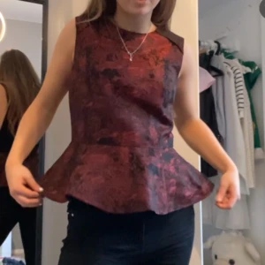 Vinröd peplum topp med mönster - Säljer den här skit snygga toppen som bara är använd få gånger♥️♥️tror att den e från hm! Skriva om fler bilder ❤️