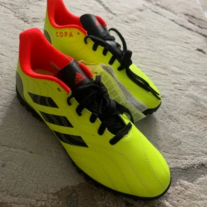 Adidas Copa fotbollsskor  - Säljer ett par Adidas Copa fotbollsskor i neon-gul färg med svarta detaljer. Helt nya och oanvända i original förpackning med prislapp på 