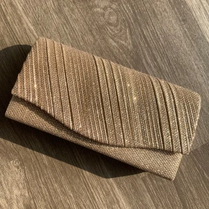 Guld glittrig kuvert väska - Använd endast en gång till bal. Den har även en kedja så man kan välja om man vill hålla den eller ha på sig den. Blädra vid föer bilder>> ❤️