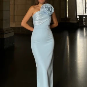 Ljusblå långklänning med rosett och oneshoulder - Aldrig använd, PRISLAPP kvar. Säljer en elegant ljusblå långklänning med en stor dekorativ rosett på axeln. Klänningen har oneshoulder-design och figurnära passform, perfekt för bal eller fest. Materialet är tjockt och ger en lyxig känsla. Köpt för 3800kr och säljs pga butiken där den är inköpt ej tillämpar bytesrätt eller öppetköp. Superfin klänning och jag är ledsen att behöva sälja den! Jag hoppas den kan komma någon annan till nytta 🩵strl 36/38 men tycker den sitter som 36 snarare.