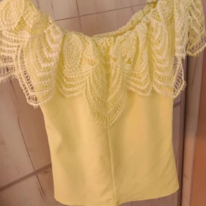 Gul offshouldertopp - Säljer en söt gul topp perfekt för sommaren! Toppen är en mer starkare gul i verkligheten och längre än på bilderna! Sista bilden är min och då har jag vikt in den!💕
