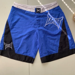 Tapout MMA Shorts - Säljer ett par blåa Tapout mma short. Starkt material som håller bra och de är lätta att röra sig runt i.