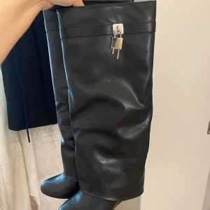 Svarta höga stövlar med låsdetalj - Säljer dessa då dom aldrig kommer till användning. Helt nya endast testade. 